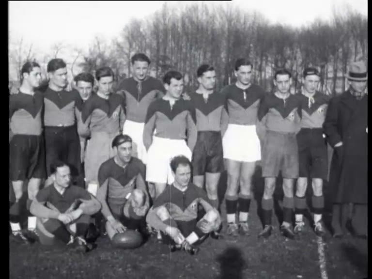 Zwart-witfilmbeeld uit 1933 van één rugbyteam dat poseert vóór AAC tegen AVRC in Amsterdam; de bron vermeldt niet welke ploeg dit is.