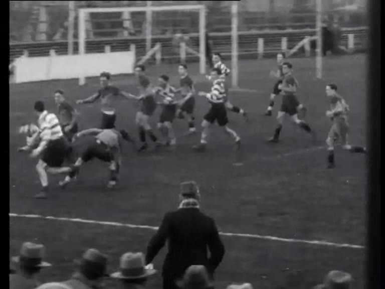 Zwart-witfilmbeeld van AAC en ARVC die na een scrum om balbezit strijden in Amsterdam in 1933.