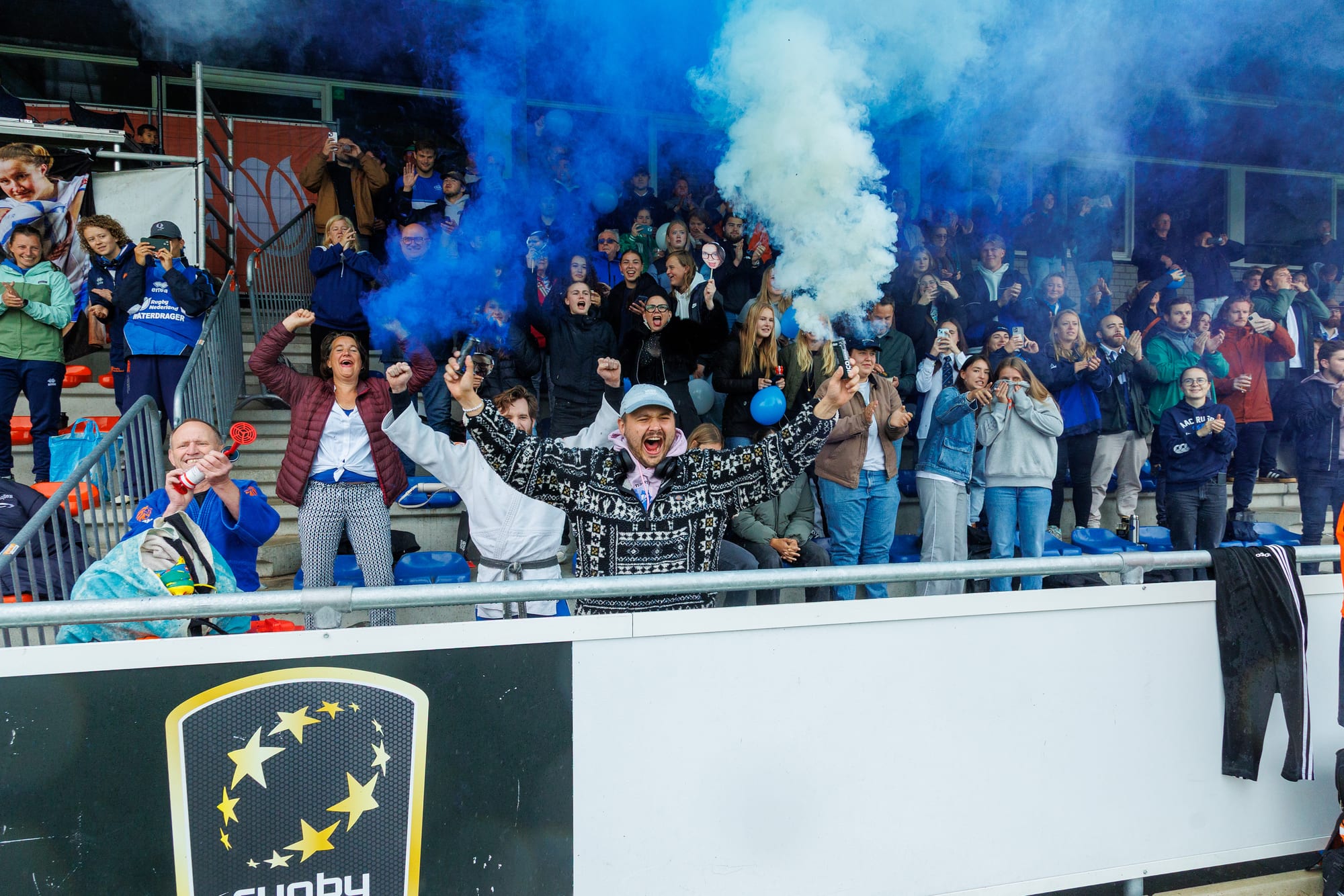 AAC supporters vieren in de tribune met blauwe rook bij de dames Ereklasse finale
