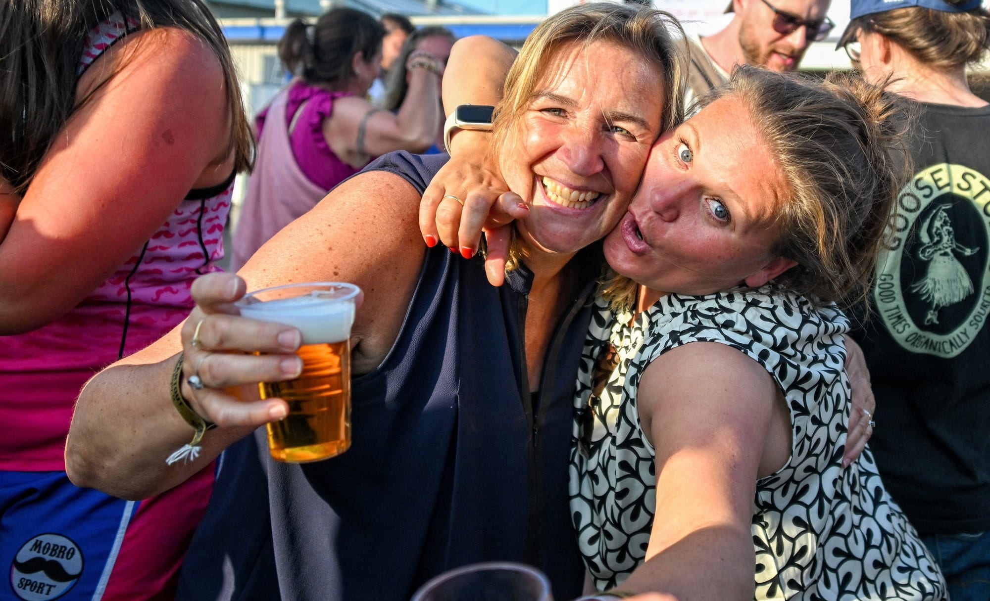 Two spelers omhelzen elkaar en proosten met bier bij de Amsterdam Sevens feest na het toernooi