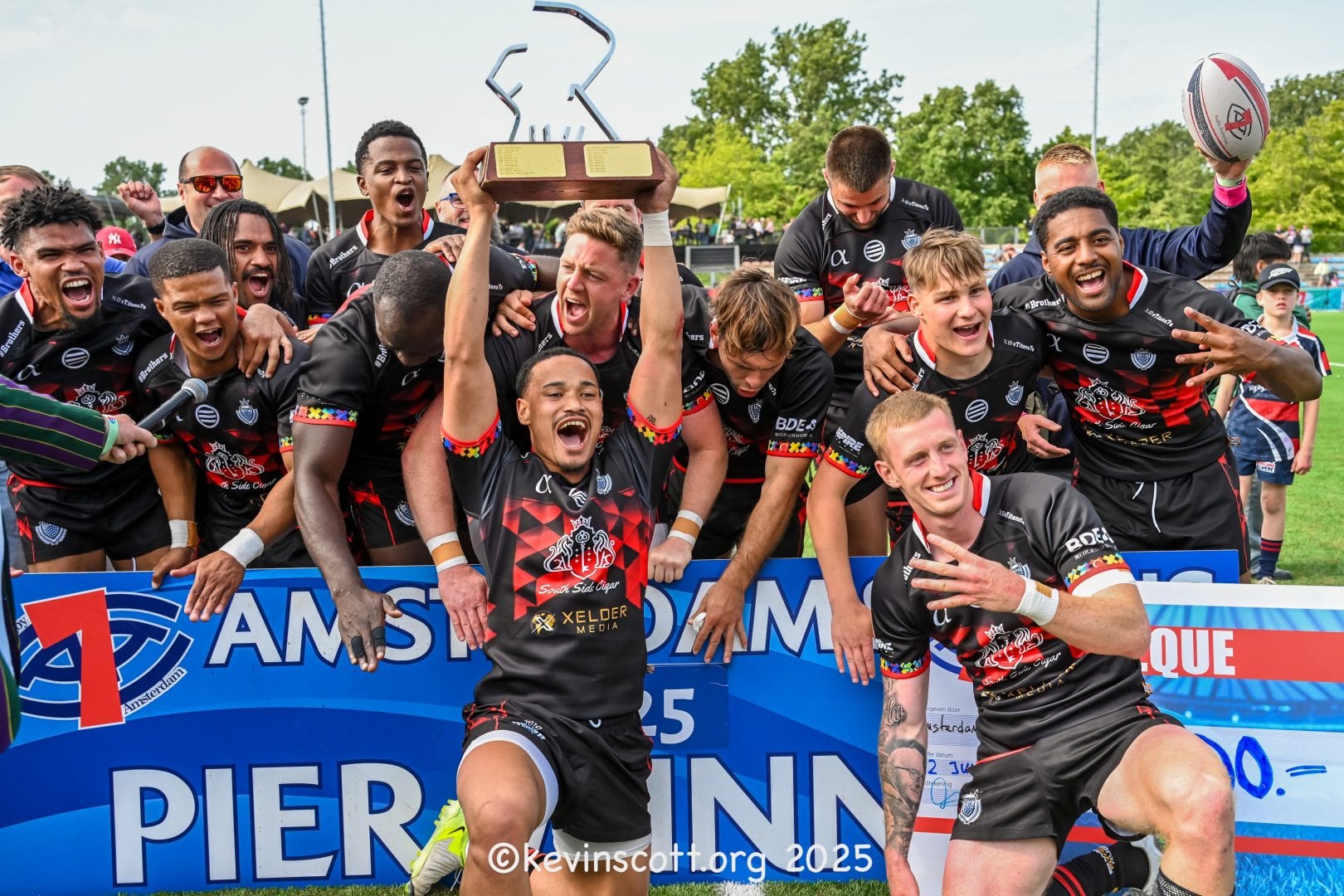 De winnaars tillen de trofee op tijdens de Elite Pier-finale van de Amsterdam Sevens 2025